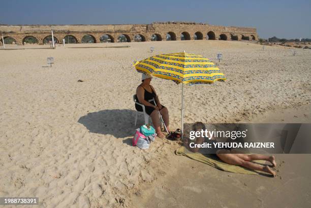 Israeli women sunbathe near an ancient roman aqueduct in the Israeli coastal city of Cesarea on September 9, 2008. The aqueduct was built by King...