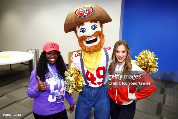 The San Francisco 49ers mascot Sourdough Sam poses for a photo with Brandyss Howard of the Super Bowl Host Committee and a 49ers cheerleader at the...