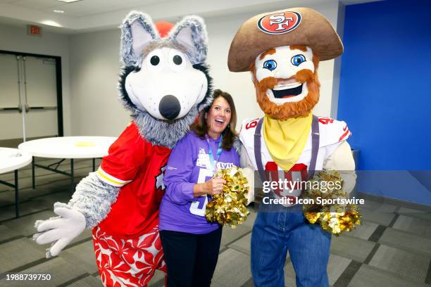 Volunteer poses for a photo with the San Francisco 49ers mascot Sourdough Sam and the Kansas City Chiefs mascot K. C. Wolf at the Basket of Hope...