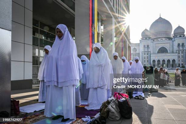 Members of the Pan-Malaysian Islamic Party pray outside the Palace of Justice , as they await the Federal Court's decision on Kelantan state's sharia...