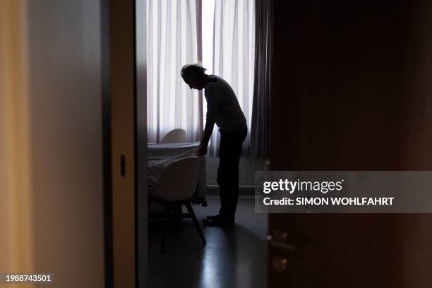 Former doctor and carer Denis Rousseaux adjusts the blanket on Lydie Imhoff after Imhoff underwent euthanasia at a hospital in Belgium, on February...