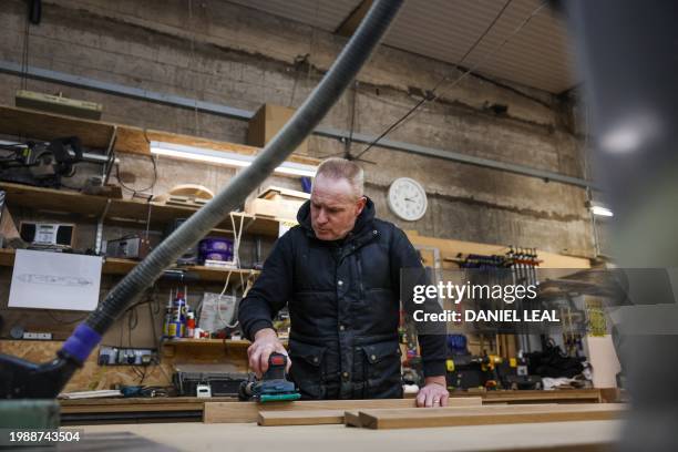 Carpenter works on wooden planks for a hybrid narrowboat at the workshop of the Ortomarine, a company specialised in the construction of electric...