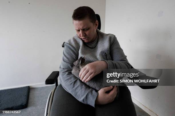 Lydie Imhoff sits in her wheelchair with her rabbit "Lucky" while spending her last day in her empty home in Besançon, France, on January 30, 2024....