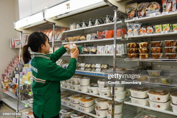 Worker restocks riceballs at a 7-Eleven convenience store, operated by Seven & i Holdings Co., in Tokyo, Japan, on Thursday, Jan. 18, 2024. Over the...