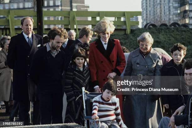 Diana, Princess of Wales , wearing a Catherine Walker coat, visits with children at the Charlie Chaplin Adventure Playground for handicapped children...