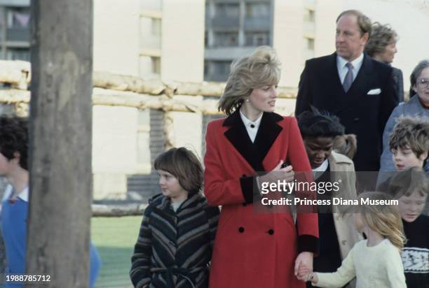 Diana, Princess of Wales , wearing a Catherine Walker coat, walks with children during her visit at the Charlie Chaplin Adventure Playground for...