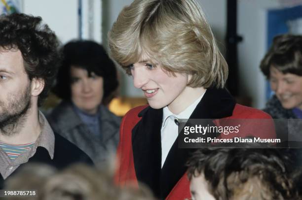 Diana, Princess of Wales , wearing a Catherine Walker coat, is surrounded by children at the Charlie Chaplin Adventure Playground for handicapped...