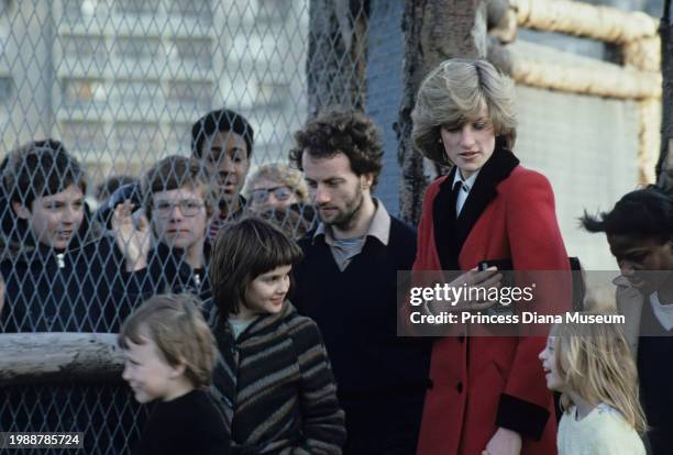 Diana, Princess of Wales , wearing a Catherine Walker coat, is surrounded by children at the Charlie Chaplin Adventure Playground for handicapped...