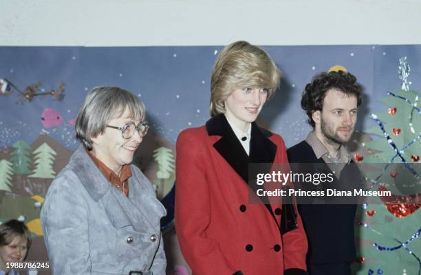 Diana, Princess of Wales , wearing a Catherine Walker coat, looks on with two unidentified people during her visit to the Charlie Chaplin Adventure...