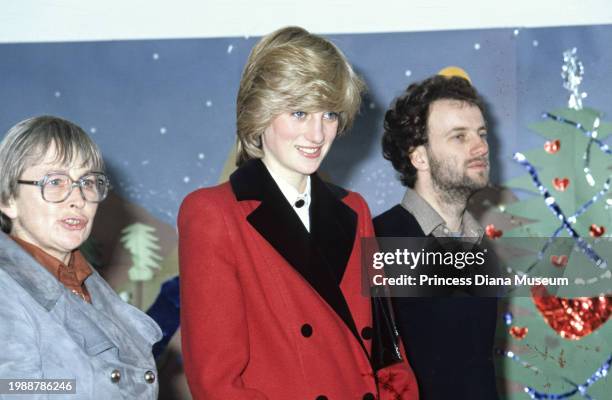 Diana, Princess of Wales , wearing a Catherine Walker coat, looks on with two unidentified people during her visit to the Charlie Chaplin Adventure...