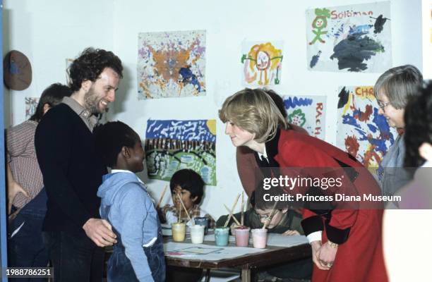 Diana, Princess of Wales , wearing a Catherine Walker coat, talks with an unidentified child at the Charlie Chaplin Adventure Playground for...
