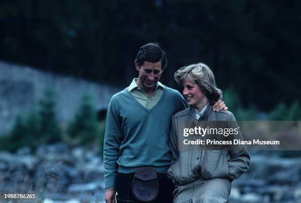 Charles III of the United Kingdom and Diana, Princess of Wales , wearing a suit designed by Bill Pashley, walk along the banks of the river Dee on...