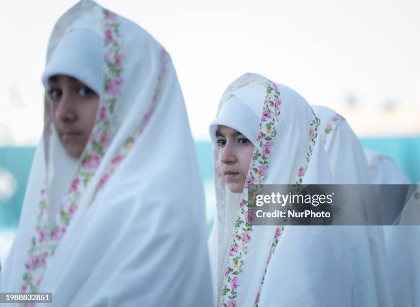 Veiled Iranian schoolgirls are looking on while participating in a ceremony at the holy mosque of Jamkaran on the outskirts of the holy city of Qom,...
