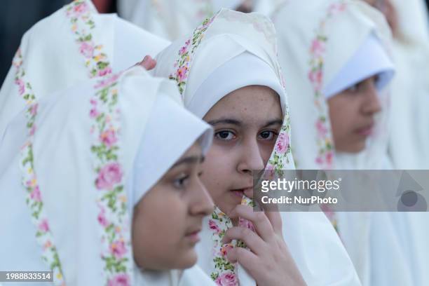Veiled Iranian schoolgirl is looking on while participating in a ceremony at the holy mosque of Jamkaran on the outskirts of the holy city of Qom,...