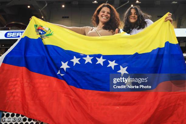 Fans of Tiburones de La Guaira of Venezuela cheer with a Venezuelan flag during a game between Venezuela and Mexico at loanDepot Park as part of...