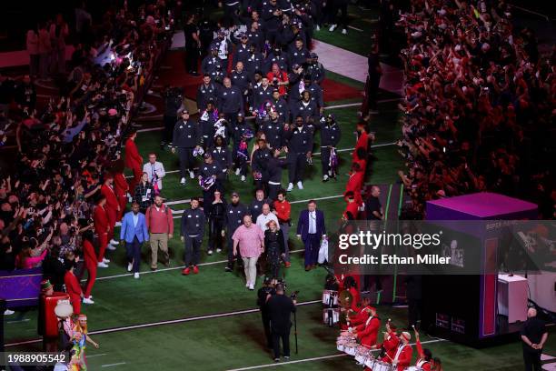 Head coach Andy Reid of the Kansas City Chiefs and his wife Tammy Reid lead the team onto the field during Super Bowl LVIII Opening Night at...