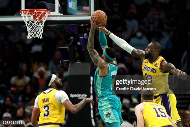 LeBron James of the Los Angeles Lakers defends a shot by Miles Bridges of the Charlotte Hornets during the first half of a game at Spectrum Center on...