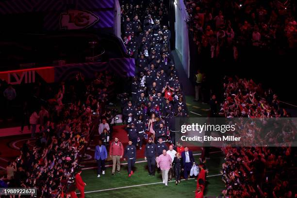 Head coach Andy Reid of the Kansas City Chiefs and his wife Tammy Reid lead the team onto the field during Super Bowl LVIII Opening Night at...