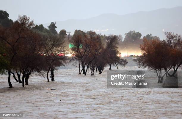 The Los Angeles River flows while swollen by storm runoff as a powerful long-duration atmospheric river storm, the second in less than a week,...