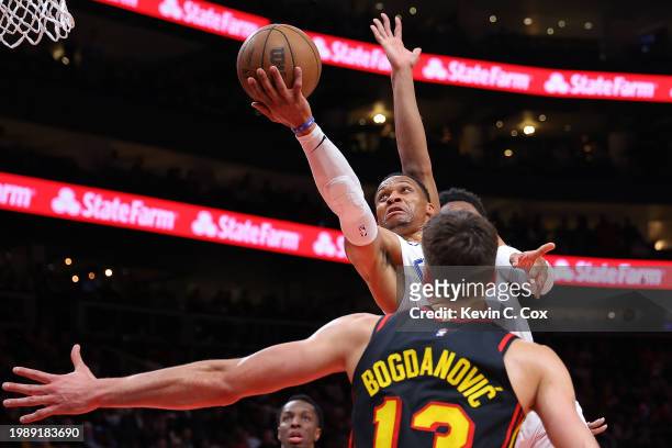 Russell Westbrook of the LA Clippers drives against Bogdan Bogdanovic and De'Andre Hunter of the Atlanta Hawks during the fourth quarter at State...