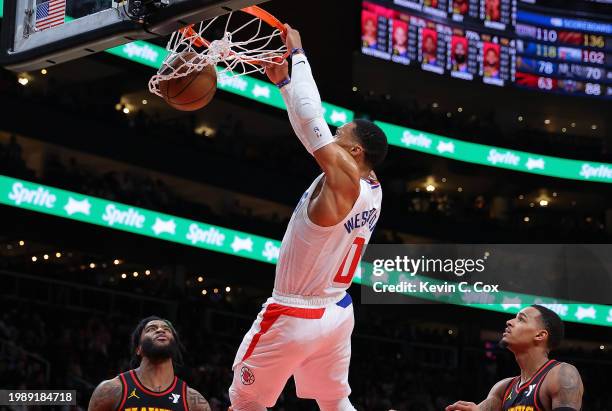 Russell Westbrook of the LA Clippers dunks against Saddiq Bey and Dejounte Murray of the Atlanta Hawks during the fourth quarter at State Farm Arena...