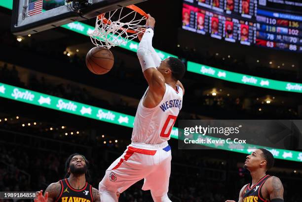 Russell Westbrook of the LA Clippers dunks against Saddiq Bey and Dejounte Murray of the Atlanta Hawks during the fourth quarter at State Farm Arena...