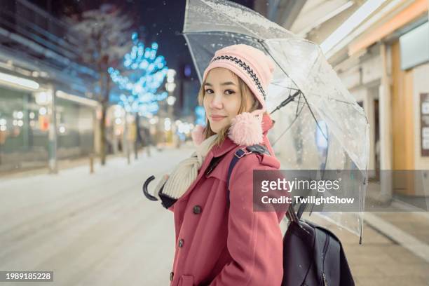 �白く厚い雪が降る夜の高山市内を女性が旅する、冬の日本を旅行する観光客に最適です。 - thick white women ストックフォトと画像