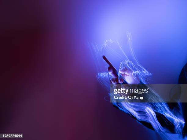 close-up of using mobile phone on holographic background - qi yang stock pictures, royalty-free photos & images