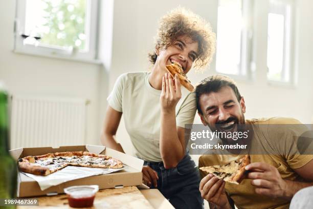 cheerful couple eating pizza on a break from home renovation process. - pizza imagens e fotografias de stock