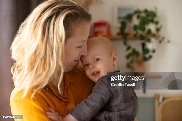 mother, baby and chest embrace in home for safety together or kid development for hug, comfort or happiness. female person, child and love in apartment for relaxing holiday for security, rest or care - woman flat chest 個照片及圖片檔