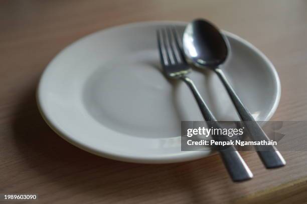 spoon fork on white plate - silver metal plate stock pictures, royalty-free photos & images