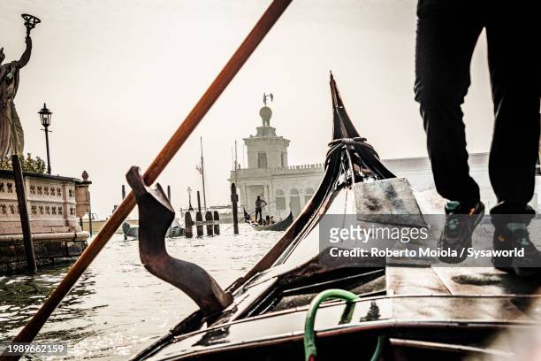gondolier rowing on the classical gondola - gondola traditional boat foto e immagini stock