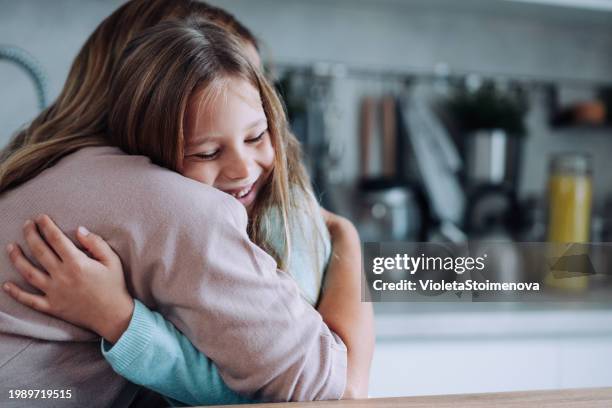 affectionate mother and daughter embracing at home. - arms around stockfoto's en -beelden