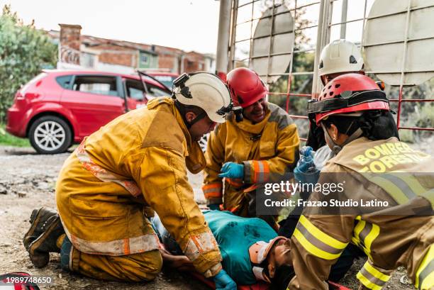 firefighters helping a accident victim - victim services stock pictures, royalty-free photos & images