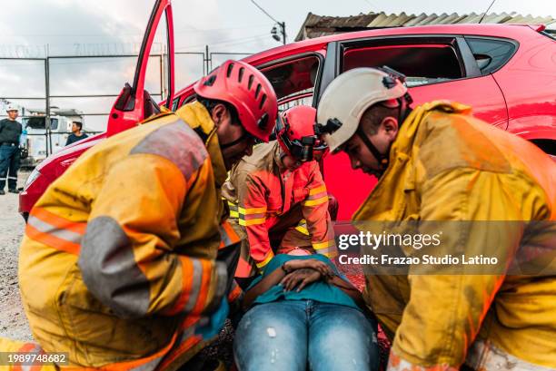 firefighters helping a accident victim - victim services stock pictures, royalty-free photos & images