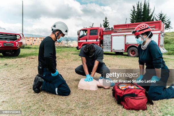 man practicing cpr on a dummy during a class - cpr training stock pictures, royalty-free photos & images