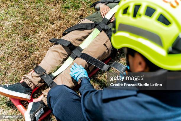 sanitäter schnallen unfallopfer auf trage - nylonband mit klettverschluss stock-fotos und bilder