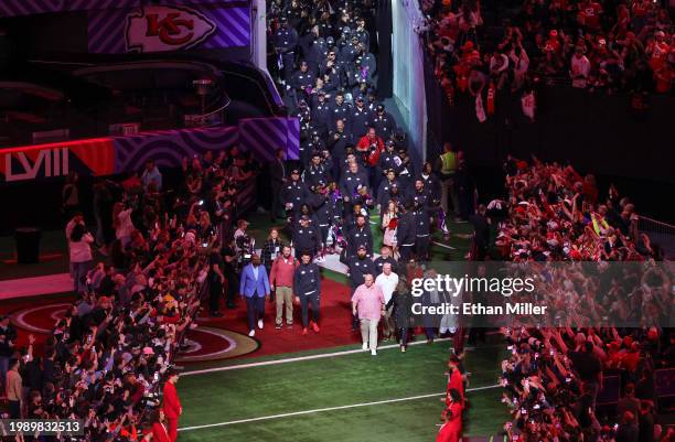 Quarterback Patrick Mahomes and tight end Travis Kelce of the Kansas City Chiefs, head coach Andy Reid and his wife Tammy Reid lead the team onto the...