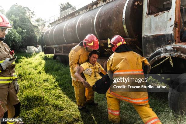 firefighters helping a car accident victim - accident victim stock pictures, royalty-free photos & images