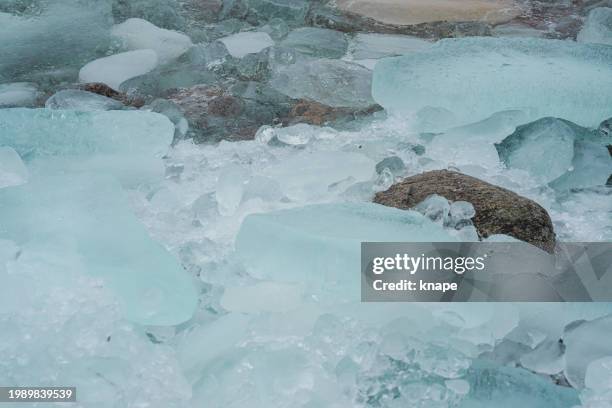 ice pebbles on shore of lake vättern in sweden - frozen water stock pictures, royalty-free photos & images