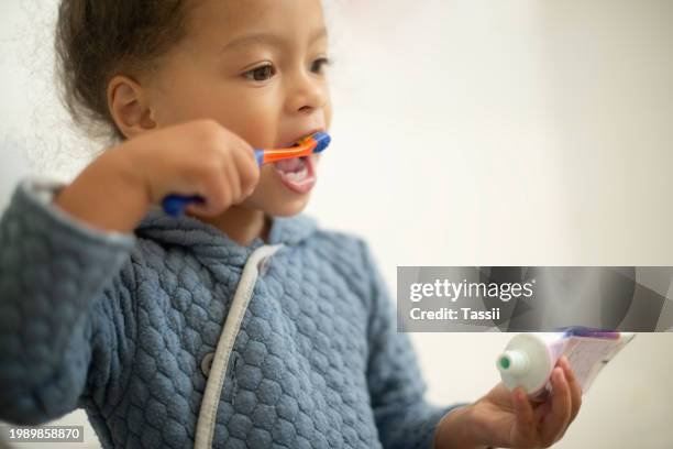 kinder-, mädchen- und zähneputzen mit zahnpasta, mundhygiene und behandlung für sauberkeit im badezimmer. weibliche person, kind und zahngesundheit zu hause, morgenroutine und schutz vor zahnfleischerkrankungen - gingivitis stock-fotos und bilder