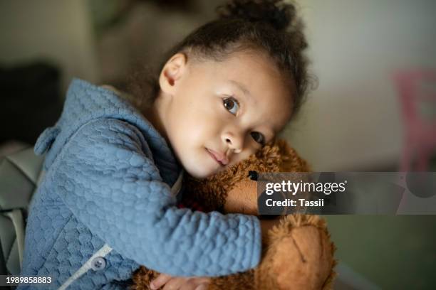sad girl, toddler and teddy bear hug for childhood, toy or love in care, support or trust at home. upset adorable little kid, lonely or child cuddle with fluffy doll in embrace, depression or trauma - poverty stock pictures, royalty-free photos & images