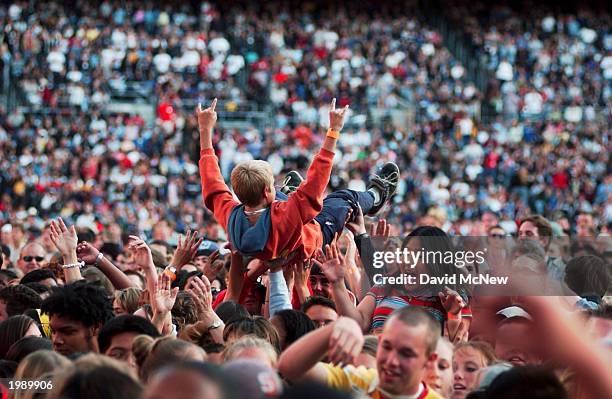 Young worshipper "surfs" across the crowd during a high-energy Christian rock performance as America's best known evangelist, 84-year-old Billy...