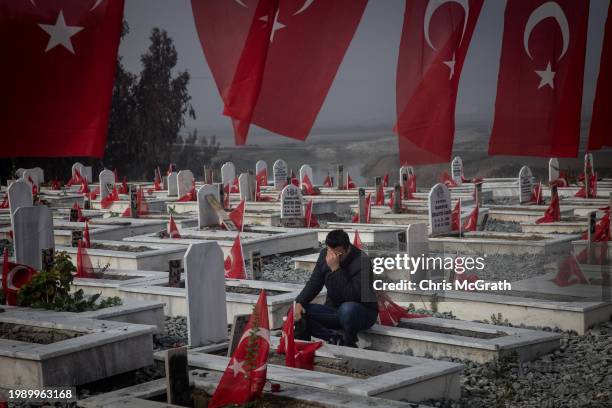 Man mourns at the grave of a loved one that was killed in last year's earthquake at a cemetery on February 06, 2024 in Hatay, Turkey. In the early...