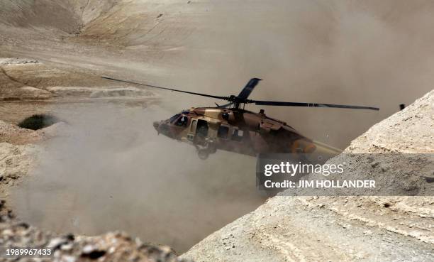 An Israeli military helicopter kicks up desert sand as it comes in for a landing to pick up Israeli Prime Minister Benjamin Netanyahu at the close of...