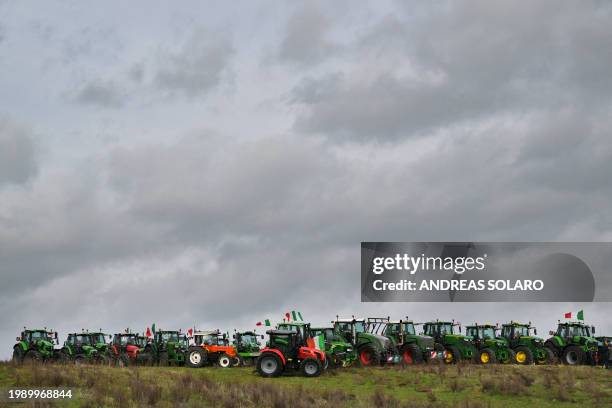 Convoy of tractors parked in a field is seen, near Rome's Grande Raccordo Anulare on the outskirts of Rome, as part of an action by farmers to...