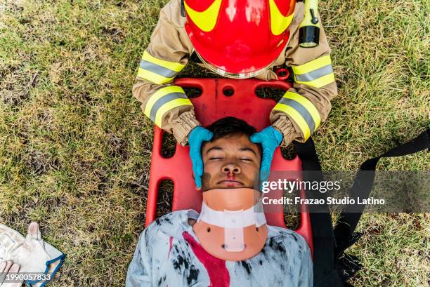 firefighters putting a neck brace on a accident victim - unconscious kid stock pictures, royalty-free photos & images