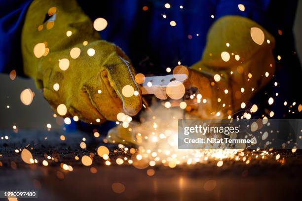 improve safety and efficiency on welding processes in the manufacturing industry. close-up shot of a welder on welding steel parts to durable and permanent join links in a steel factory. - cucitura foto e immagini stock