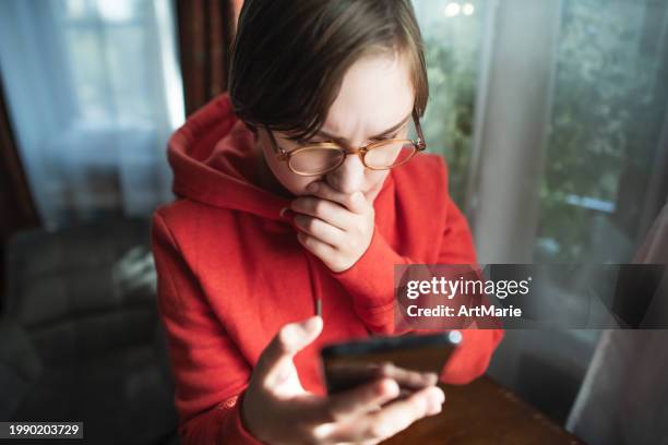 jeune femme préoccupée, triste, fatiguée et inquiète avec un smartphone à la maison en train de lire de mauvaises nouvelles ou d’avoir des problèmes ou de la fraude - voleur photos et images de collection