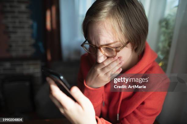giovane donna preoccupata, triste, stanca e preoccupata con lo smartphone a casa che legge alcune cattive notizie o ha problemi o frodi - vittima foto e immagini stock